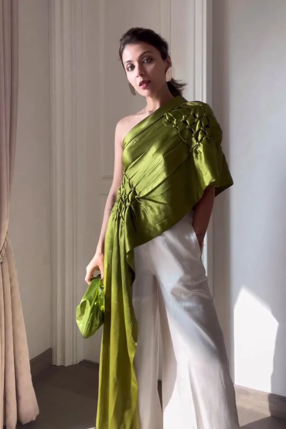 Olive draped off shoulder, asymmetric top with white wide leg pant from Aroka.