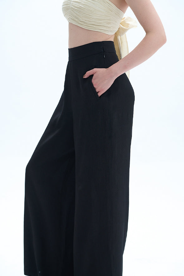 Off-white muslin ruched bandeau top with Moroccan crepe, straight fit with welt pockets Pants in black from Aroka.