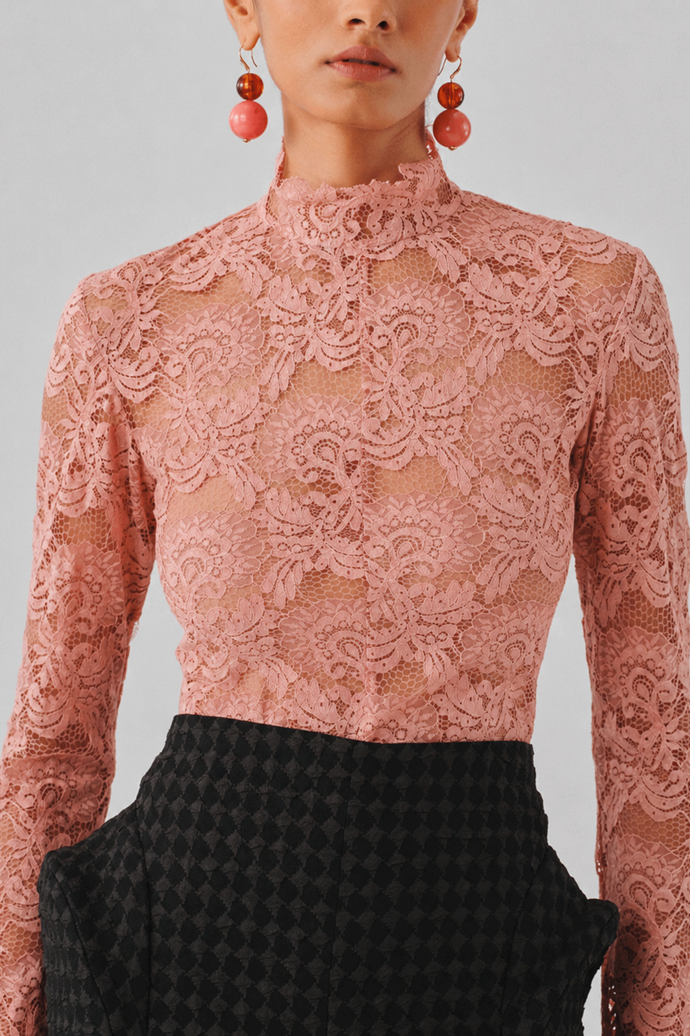 Blush pink lace top with a high neckline, close-up front view