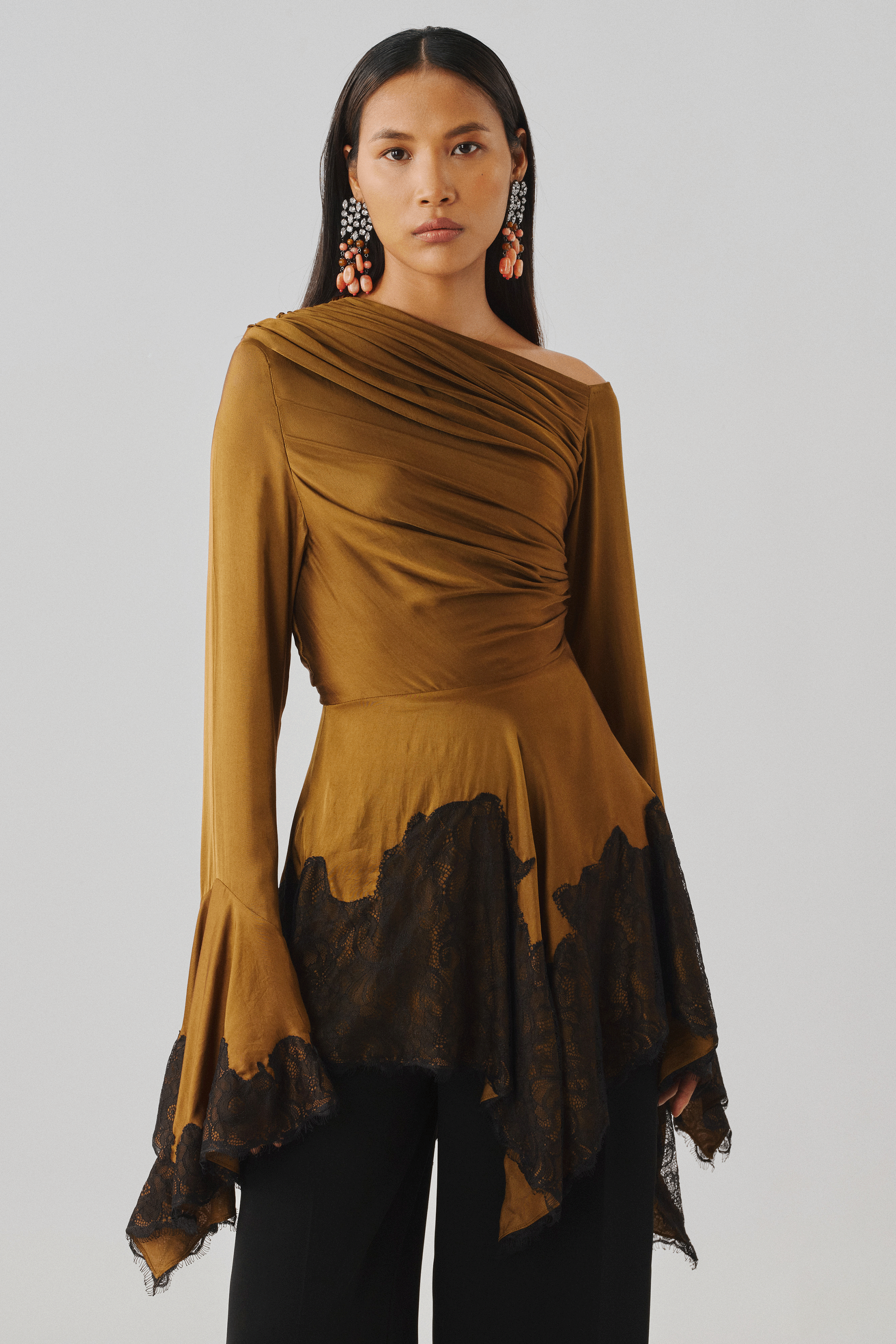 Bronze draped top with an asymmetric sleeve, styled with black pants