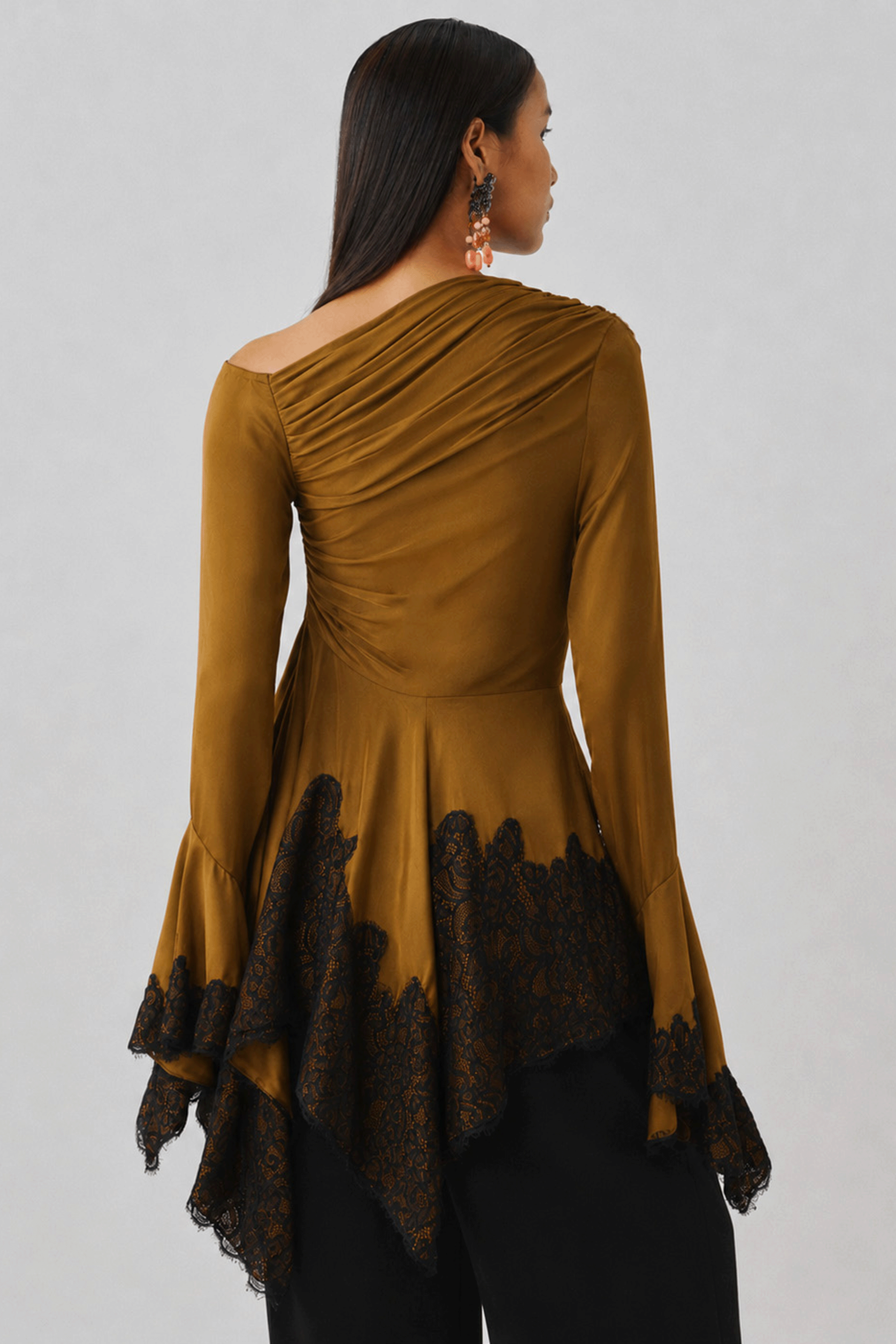Bronze draped top with an asymmetric hem, rear profile view