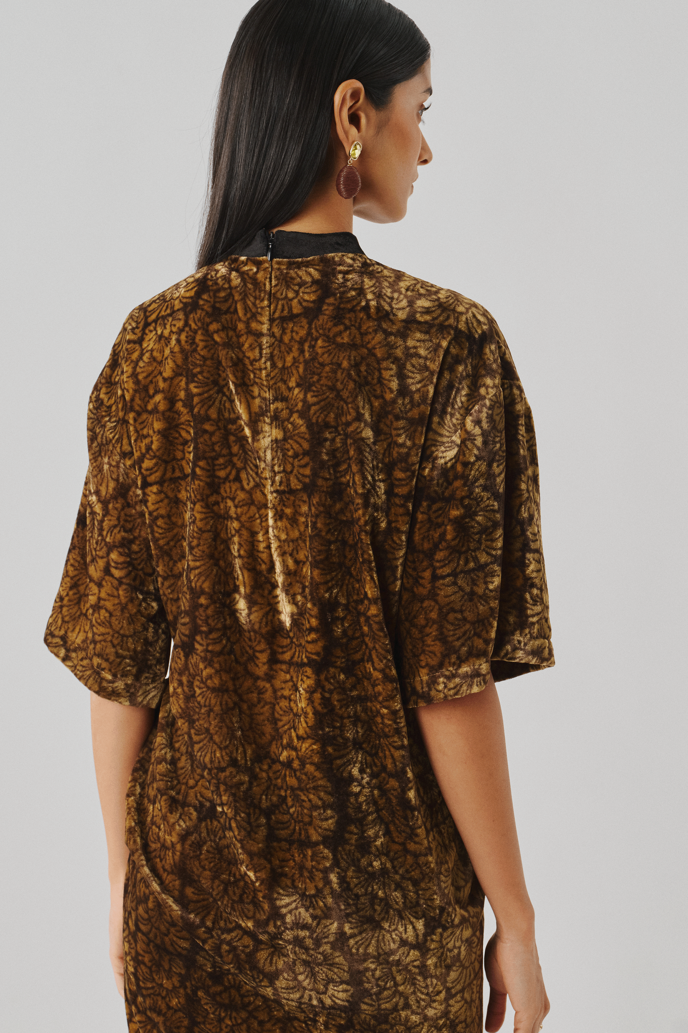 Close-up back view of a bronze metallic embossed dress with puff sleeve