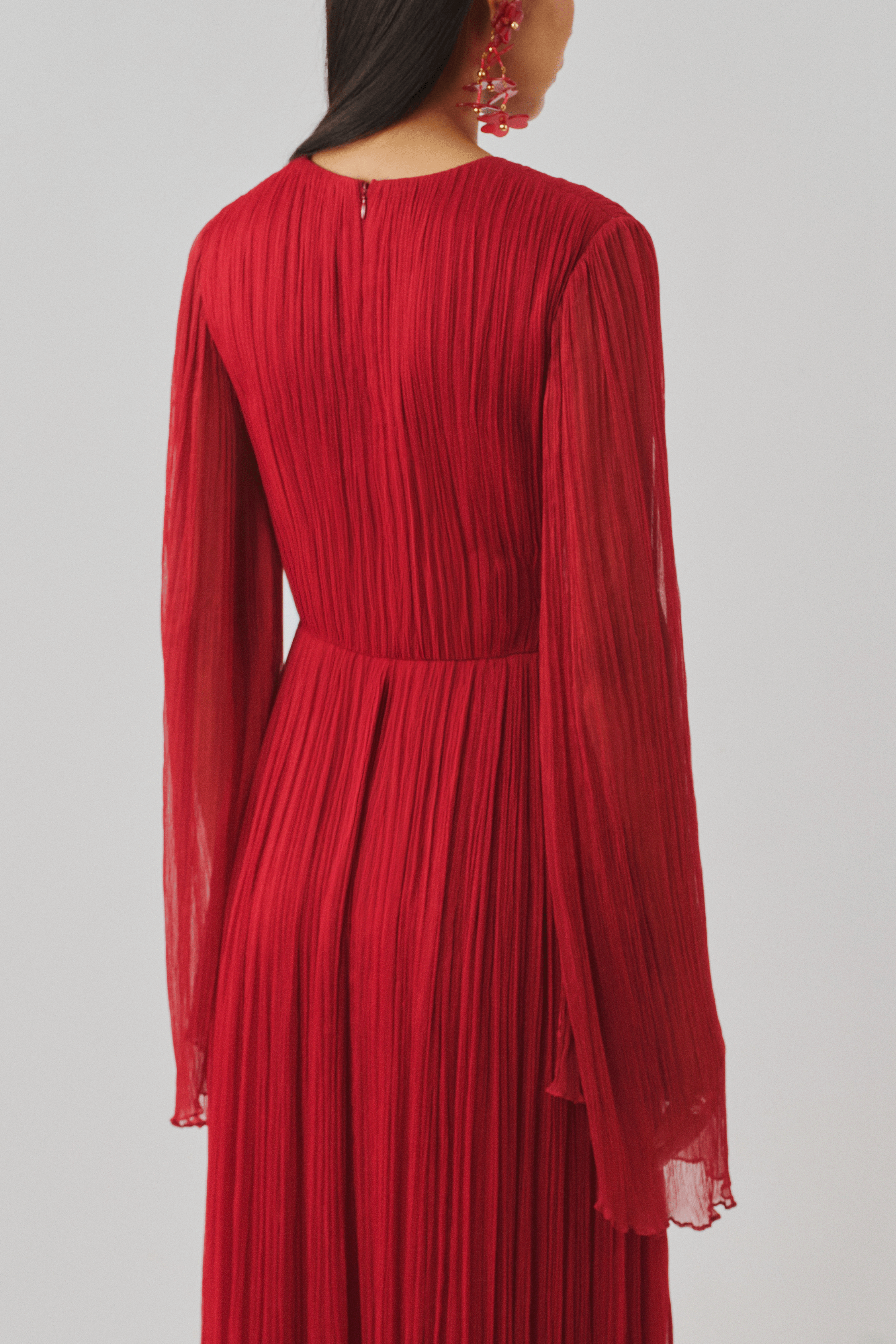 Red pleated long-sleeve gown, close-up rear detail view