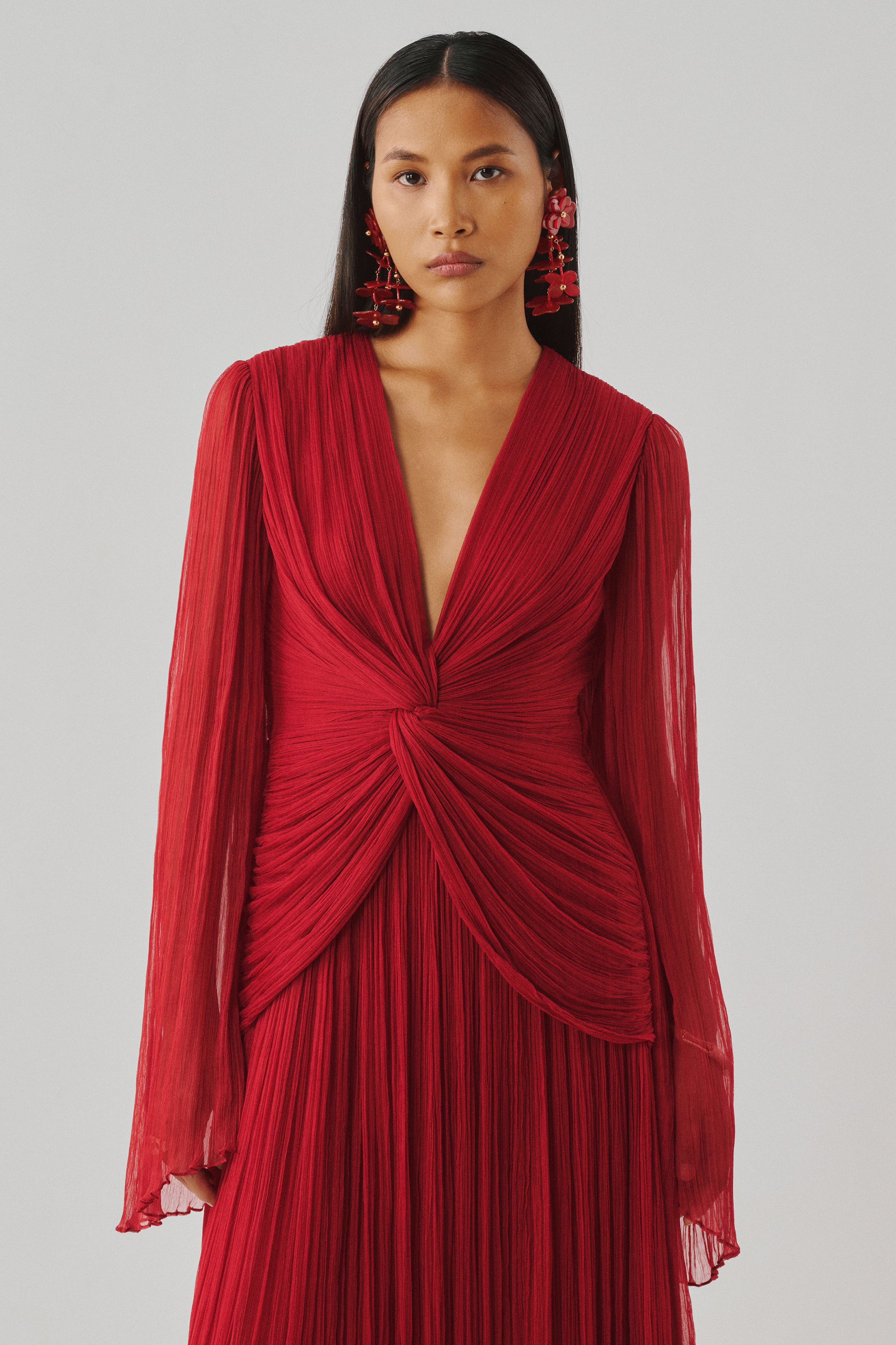 Red pleated gown with a draped wrap bodice, front close-up view