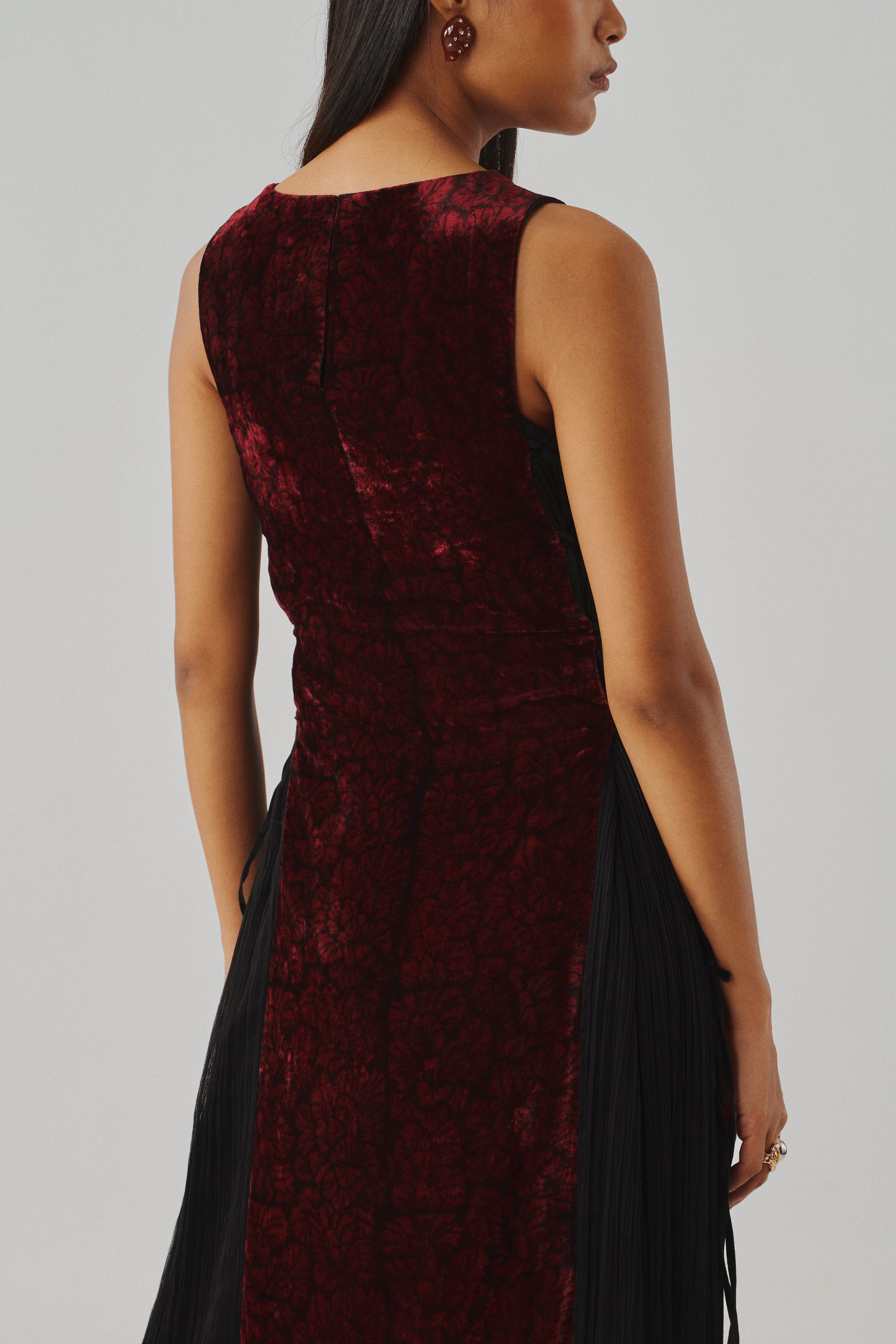 Burgundy velvet sleeveless dress with a fitted silhouette, front view