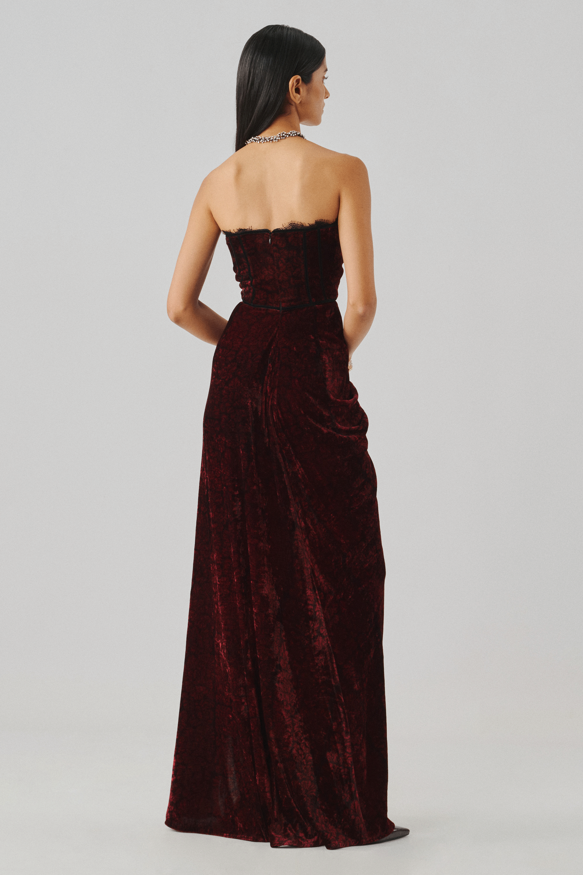 Burgundy velvet gown with a fitted column silhouette, rear view