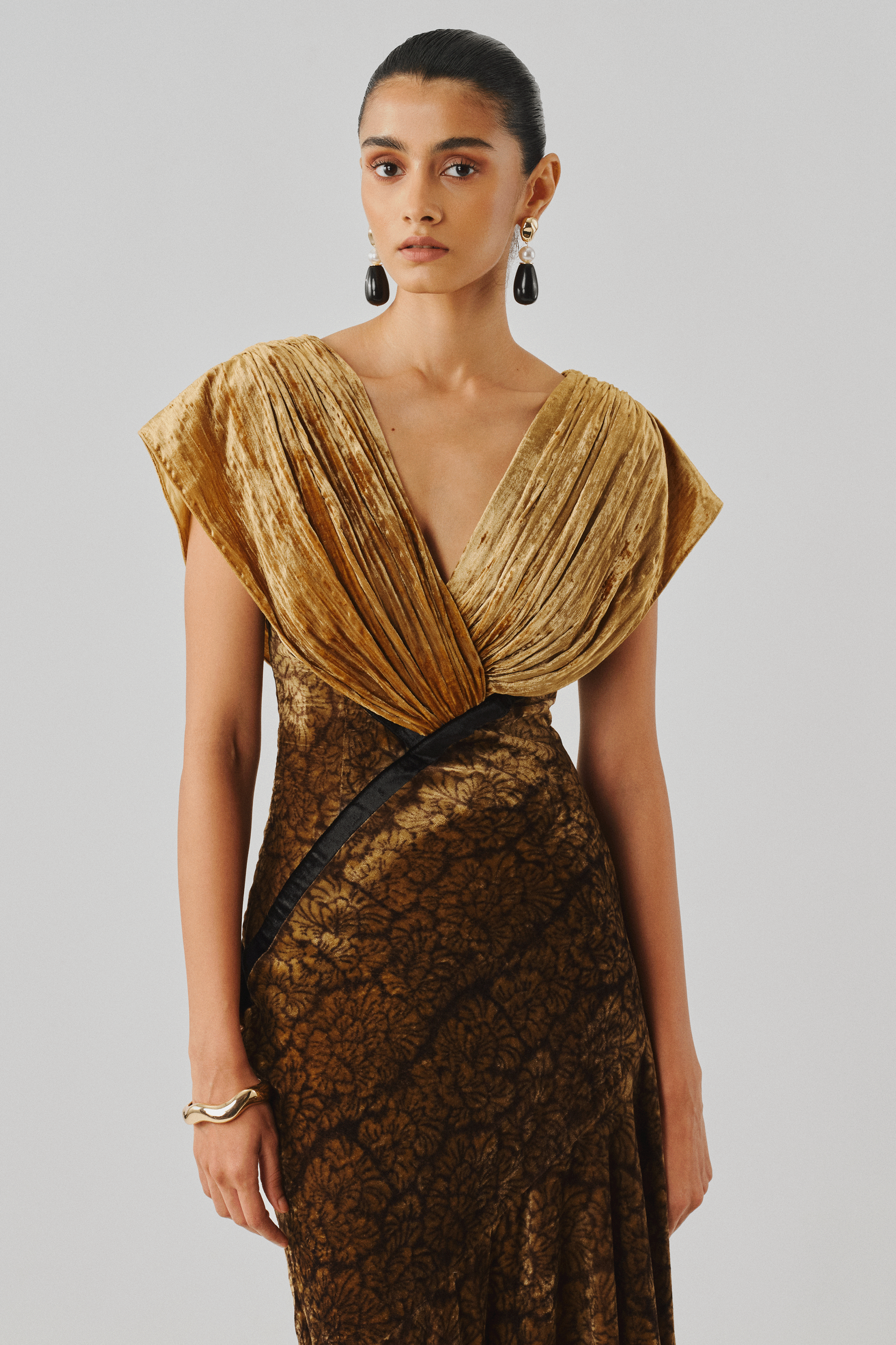 Gold velvet draped gown with an off-shoulder neckline, front view