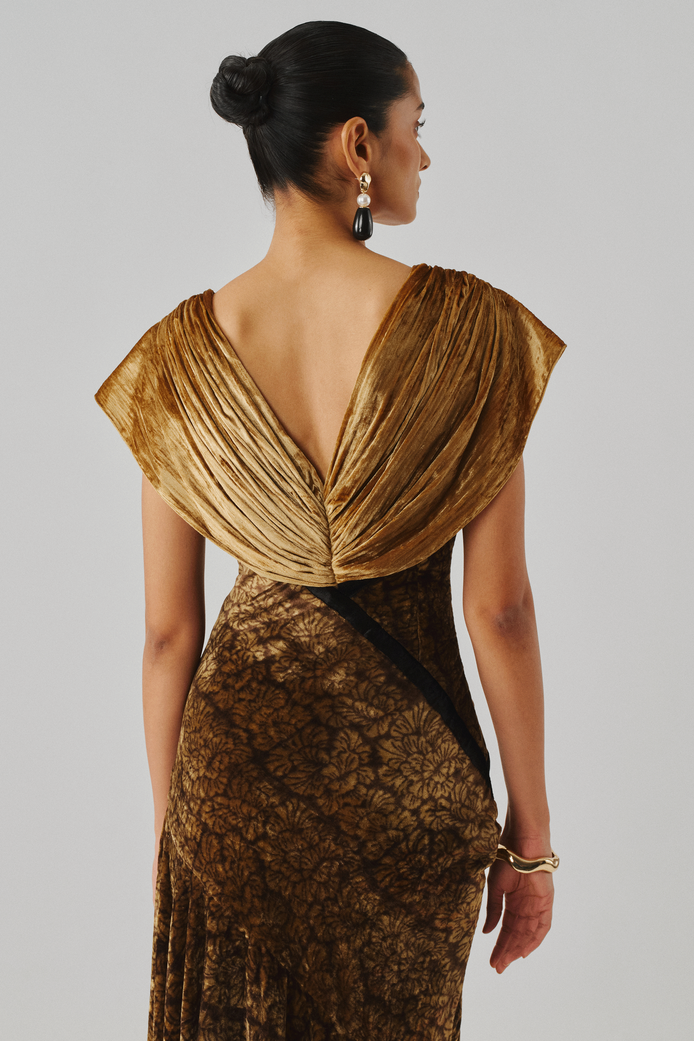 Gold velvet gown with a draped wrap back and fitted bodice, rear view