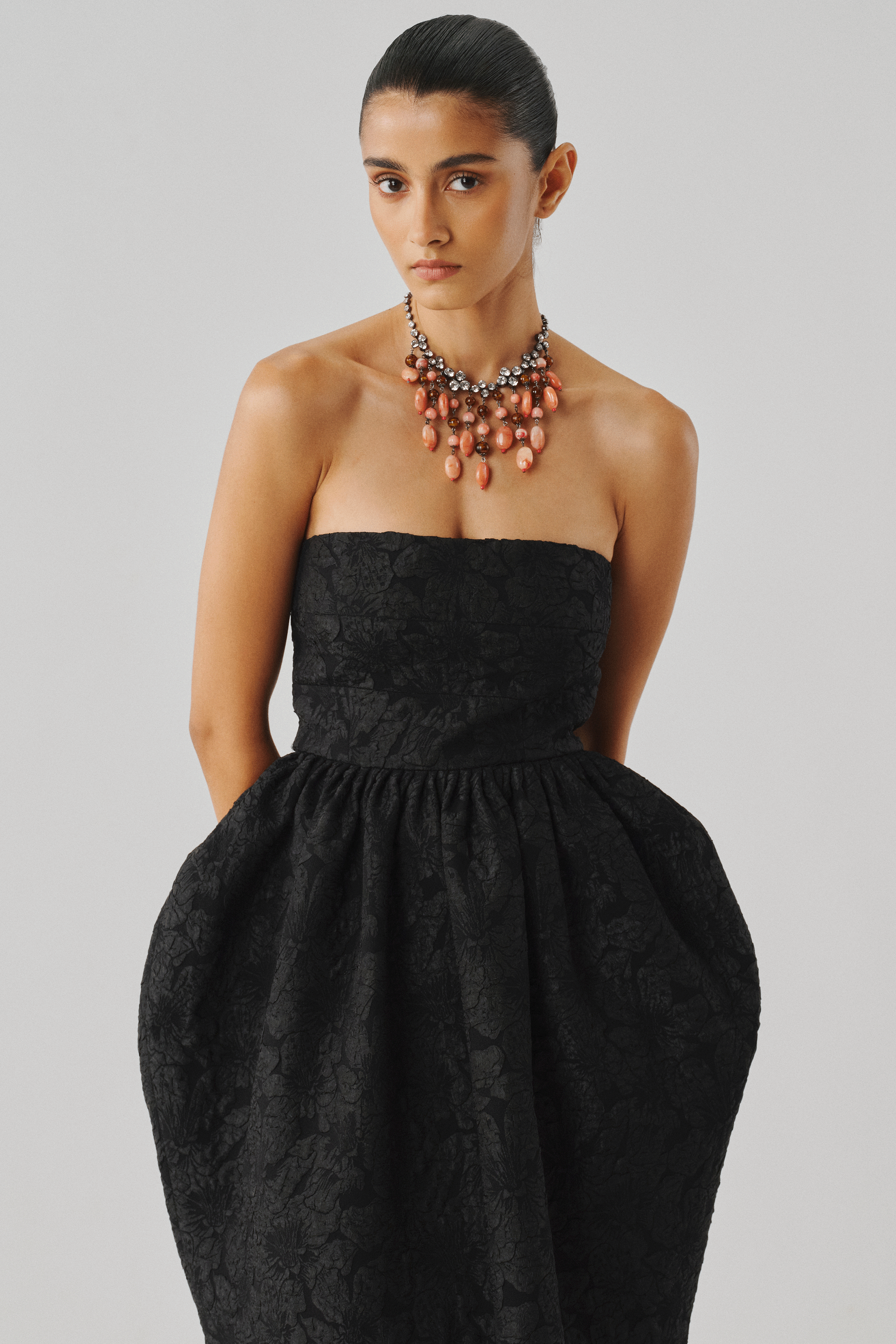 Black strapless gown with a full voluminous skirt, front close view