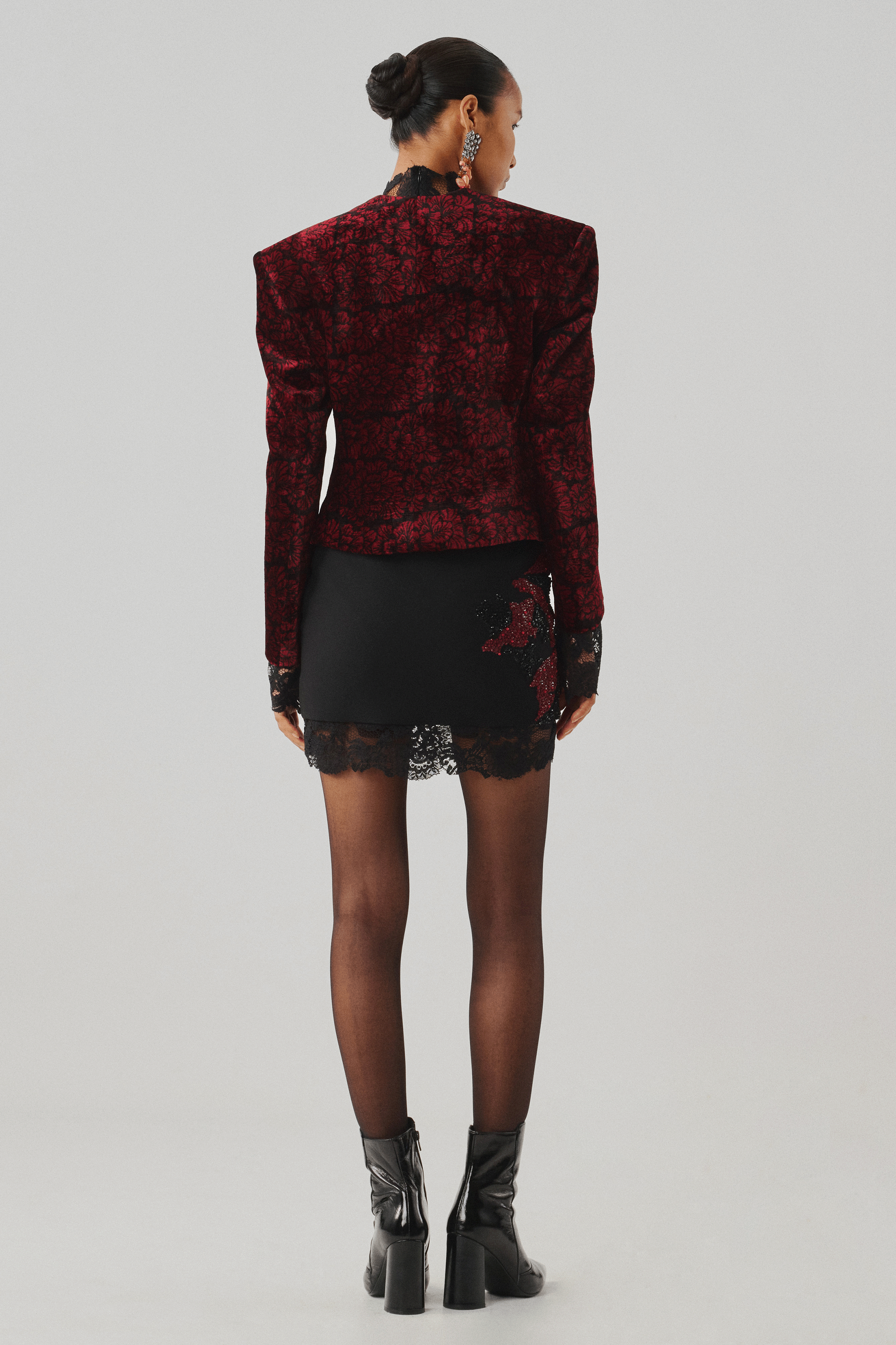 Burgundy floral jacquard jacket with a black skirt, rear view