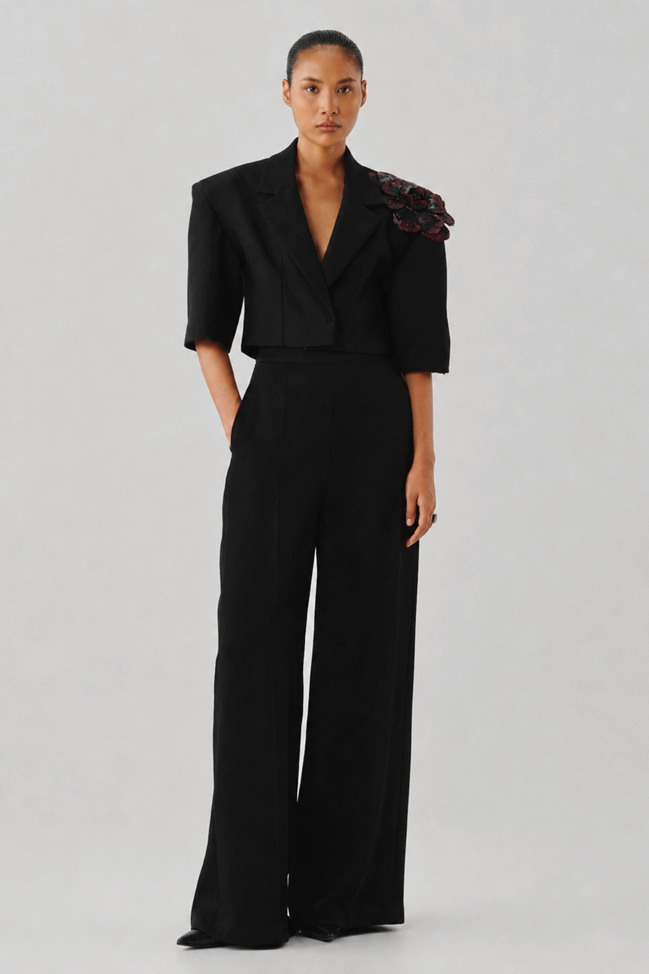 Black tailored jumpsuit with a fitted bodice, front close-up view