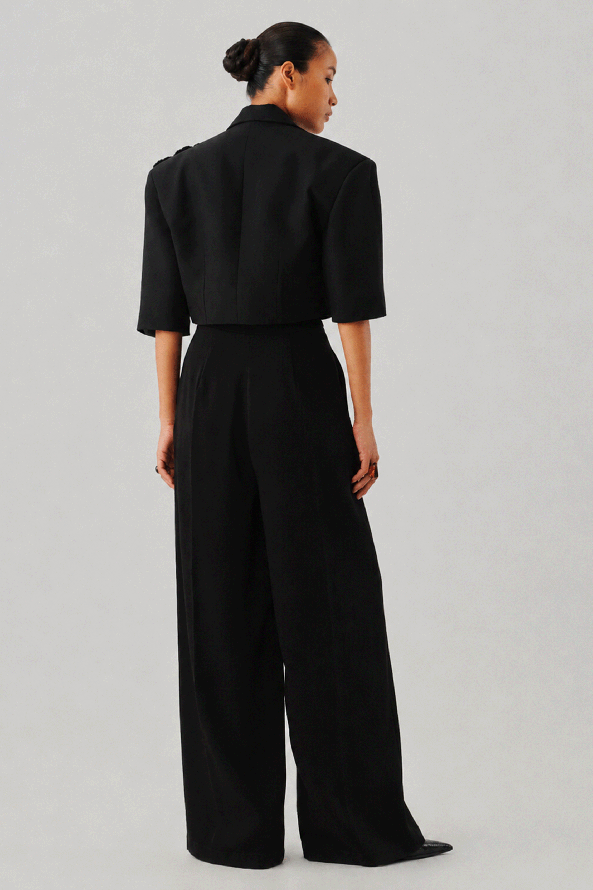 Black tailored wide-leg jumpsuit, close-up rear detail view
