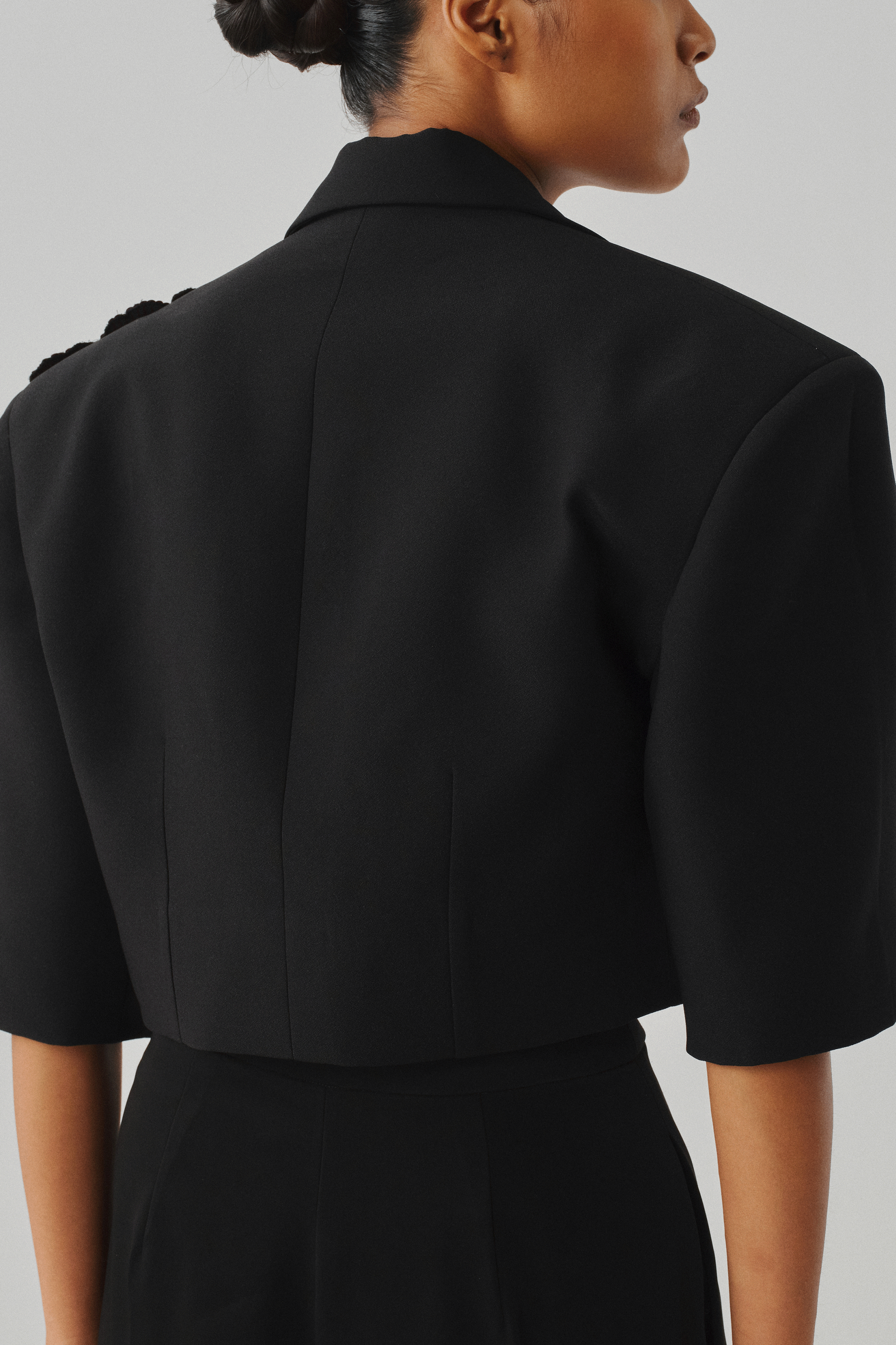 Black cropped puff-sleeve jacket, close-up rear detail view