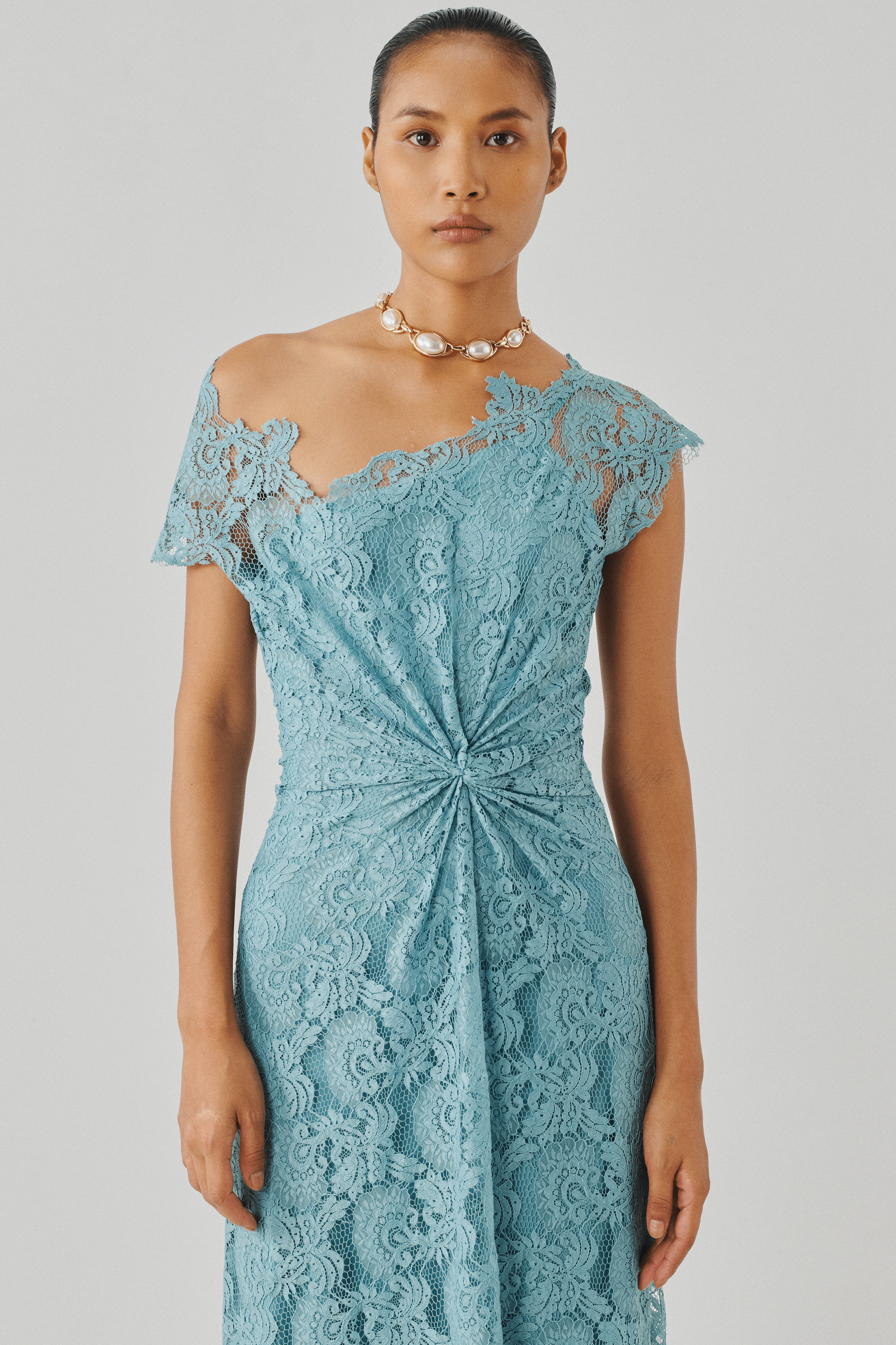 Sky blue lace gown with a draped waist knot, front view