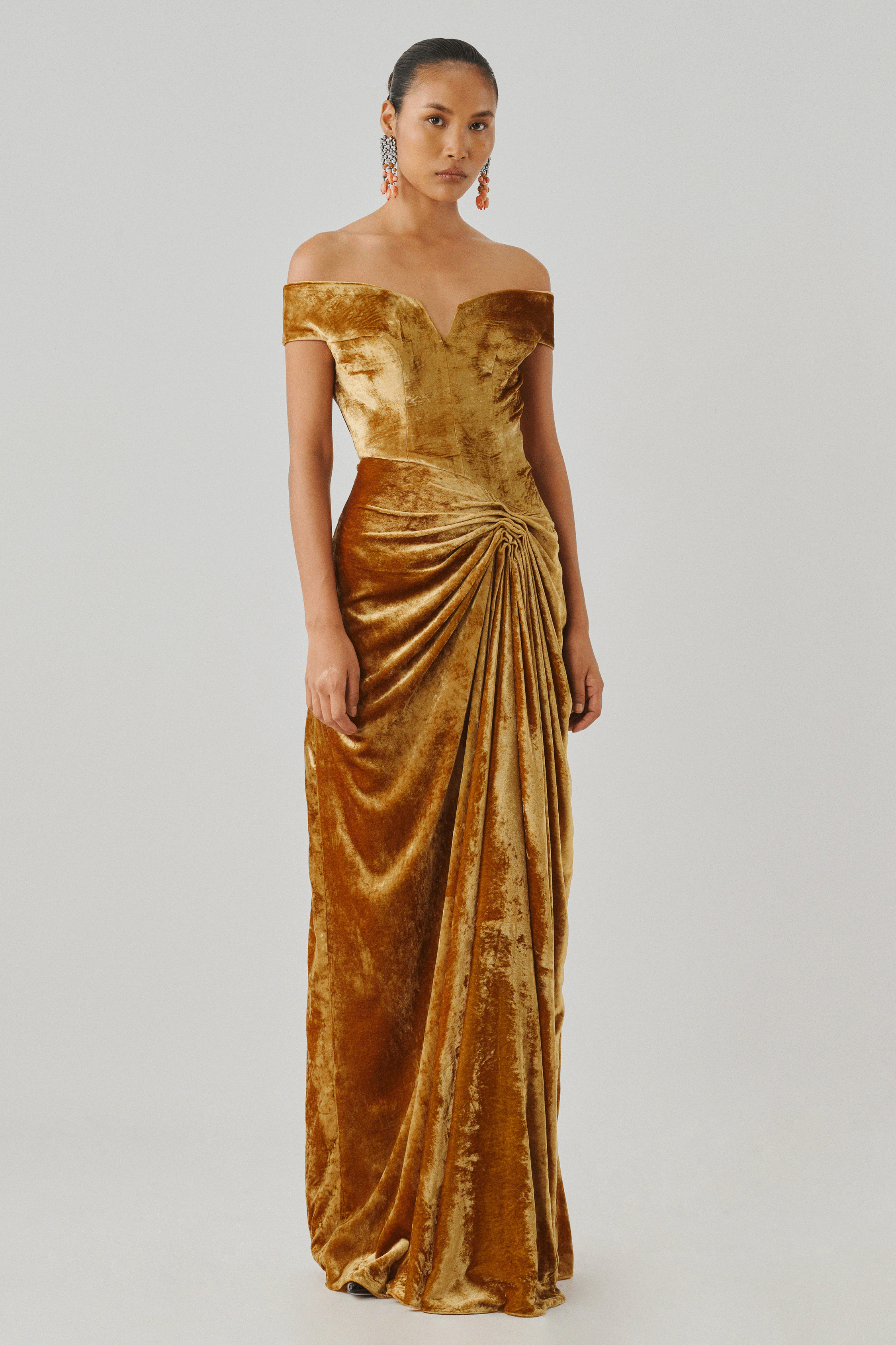 Gold velvet off-shoulder gown with fluid draping, side profile
