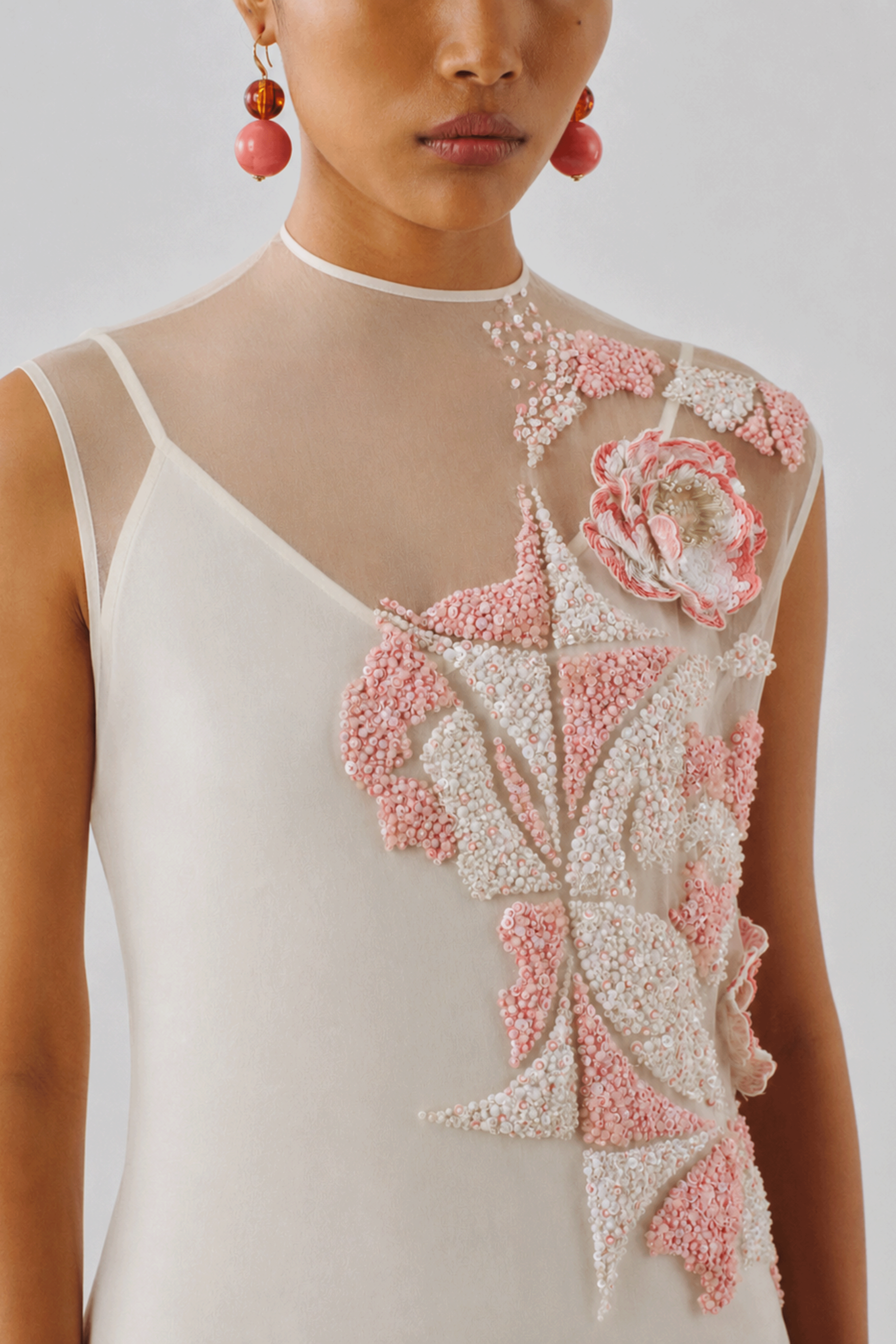 Ivory dress with a hand-embellished floral appliqué, close-up front