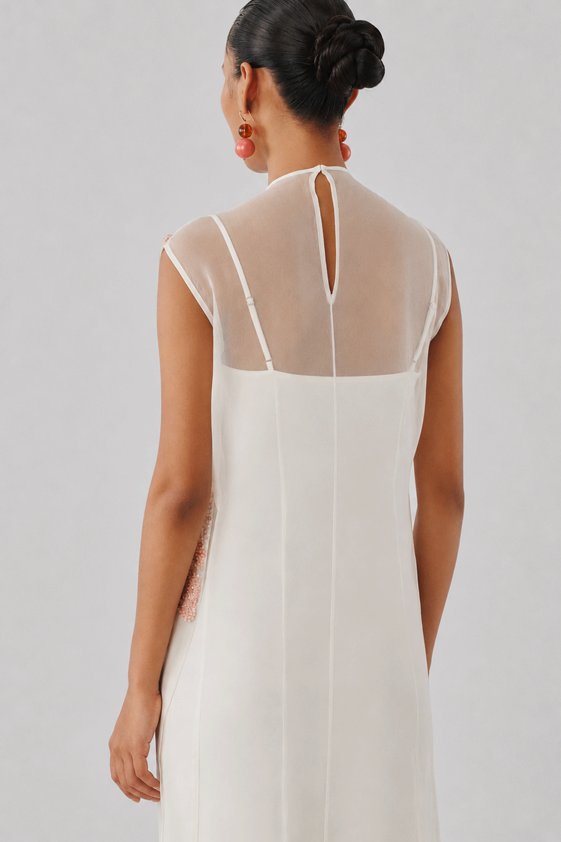 Ivory sleeveless gown with a high neckline, rear profile view
