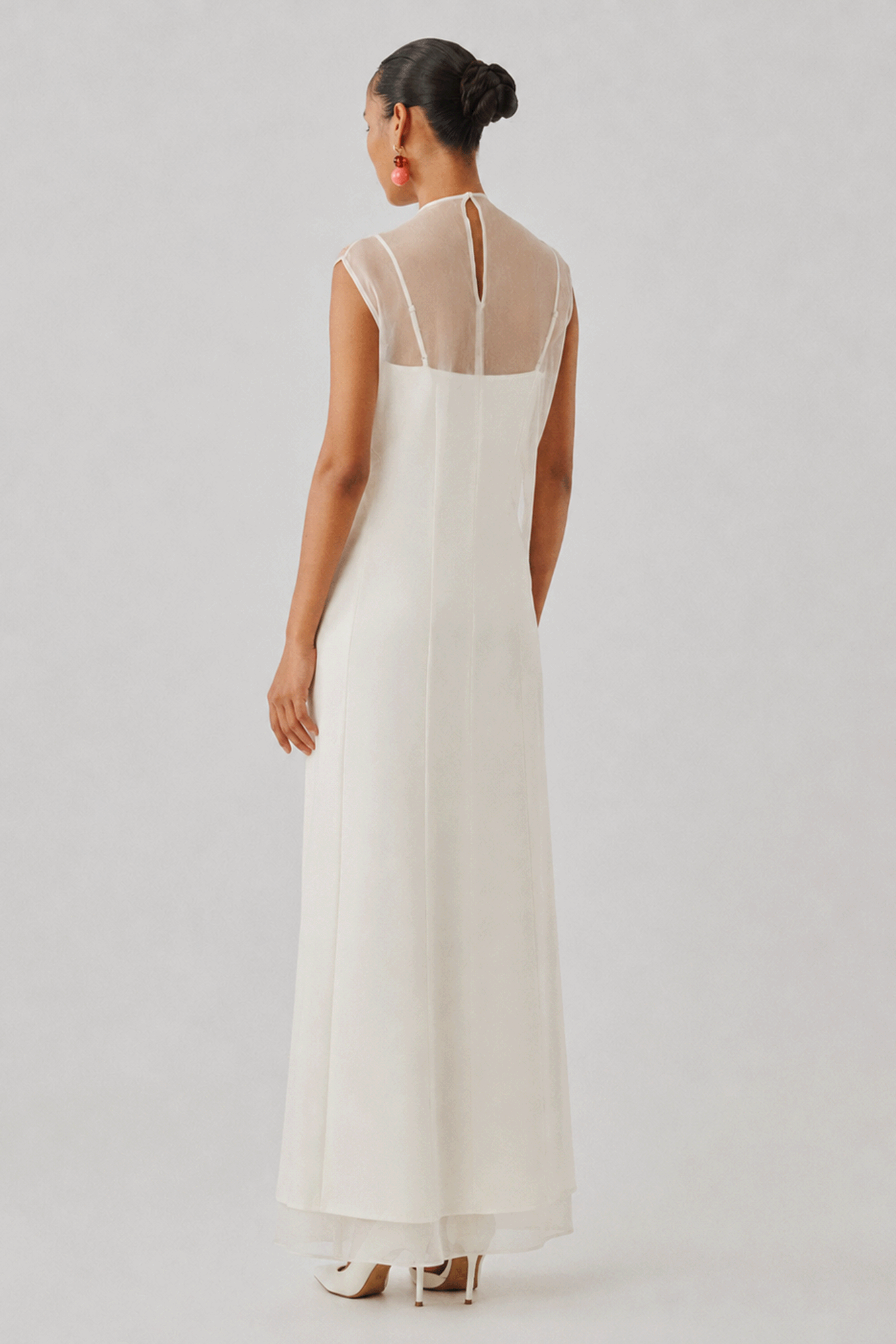 Ivory sleeveless gown with a high neckline, rear full-length view