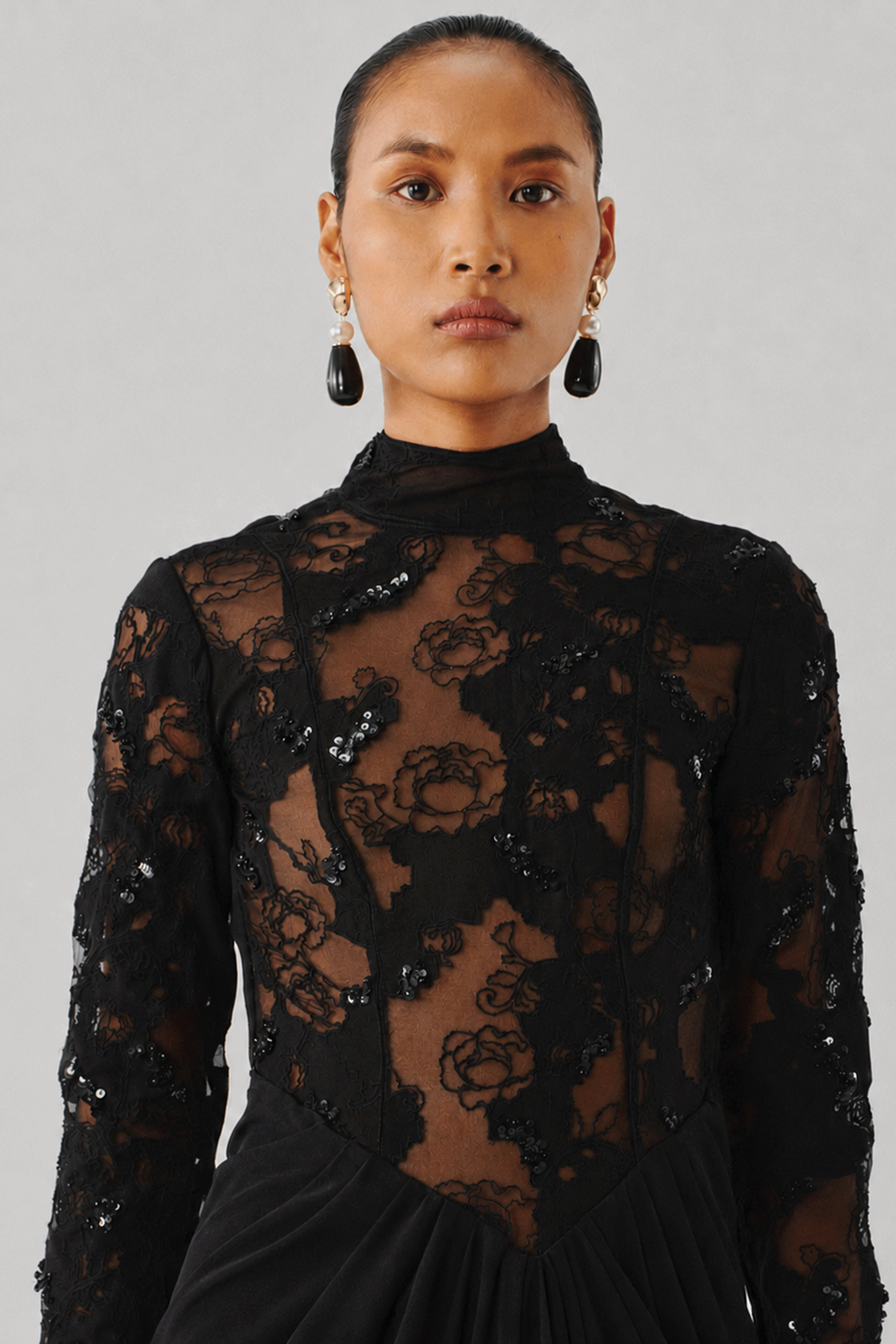 Black floral lace top with a high mock neckline, front close-up